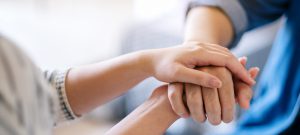 A Man And A Woman Holding Each Other Hands For Comfort And Sympa