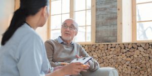 Professional Doctor Listening To Senior Mans Complaint