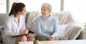 Doctor With Senior Woman In Nursing Home