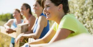 Four Women Leaning On Fence Before Outdoor Workout.